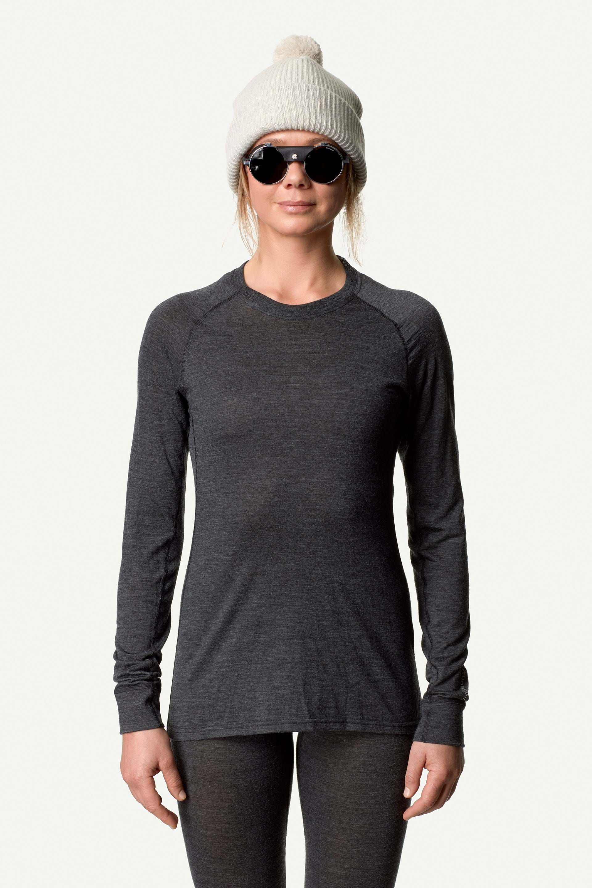 Woman wearing a black merino wool long sleeve crew shirt, perfect for skiing.